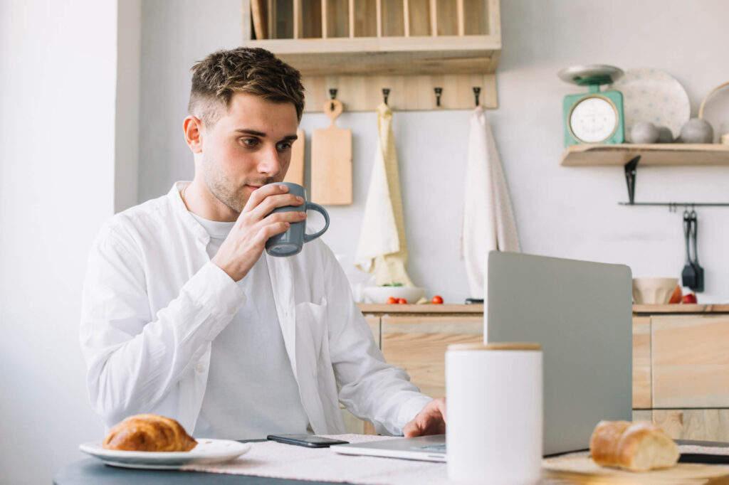 Self-employed professional working from home with laptop and coffee during registration process