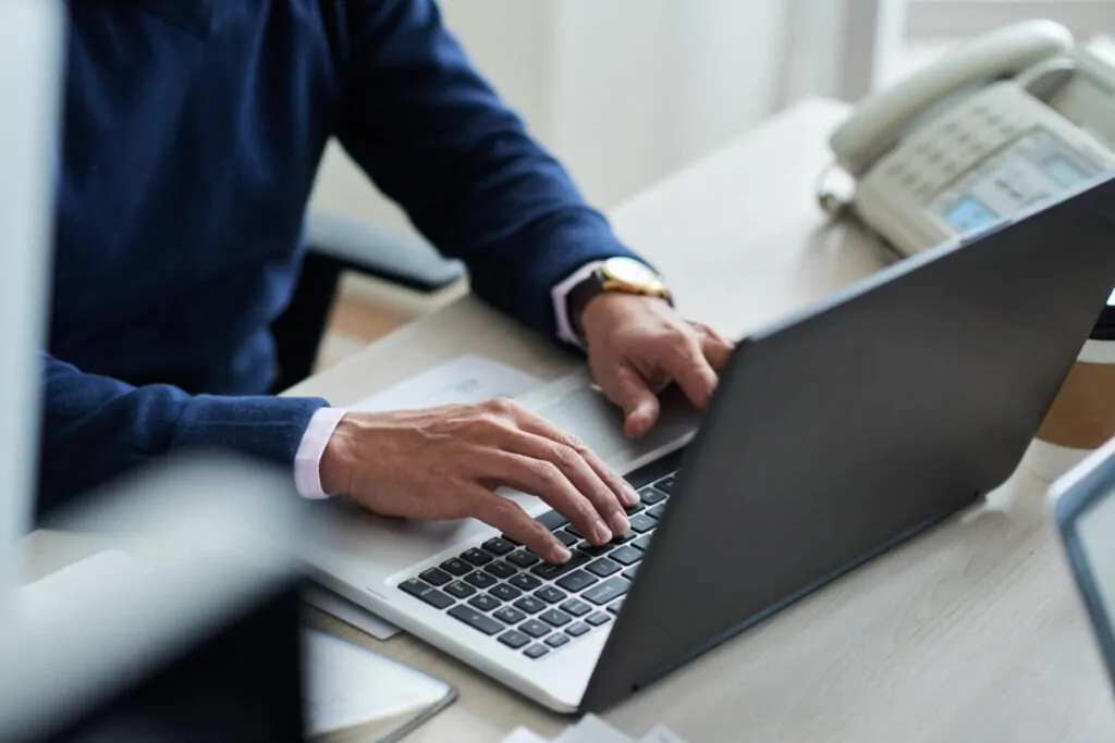 Businessman completing PAYE registration process online using a laptop.