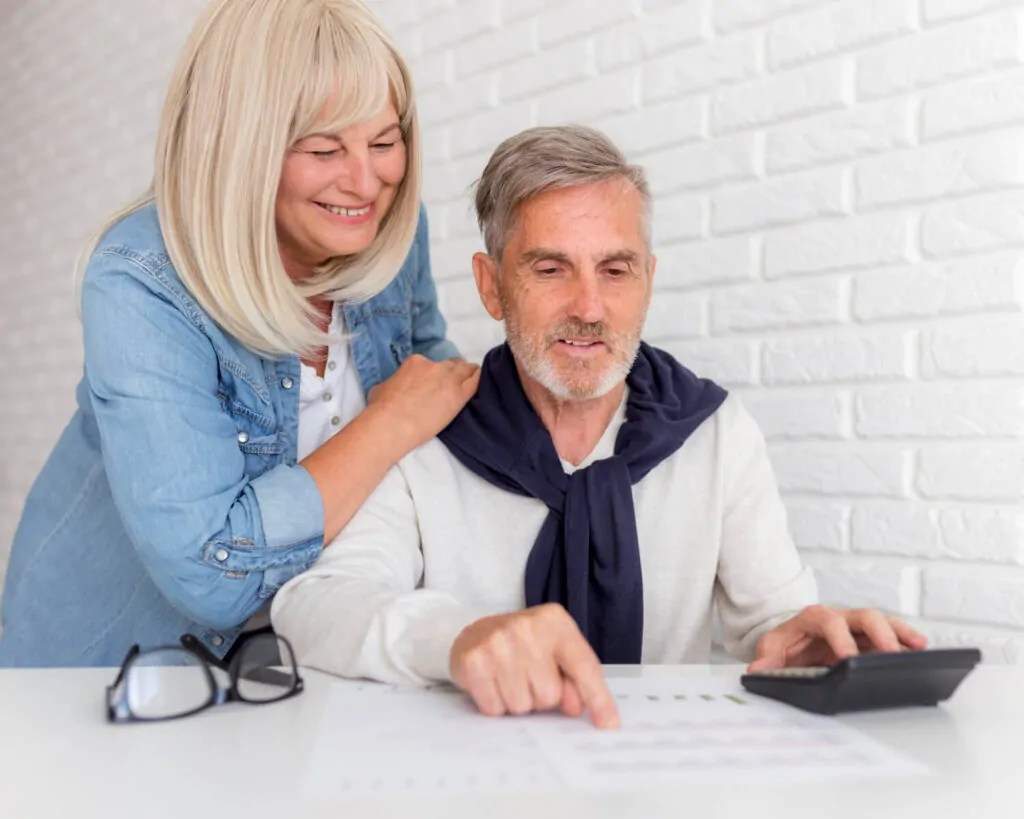 Older couple reviewing pension scheme details together at home with professional support