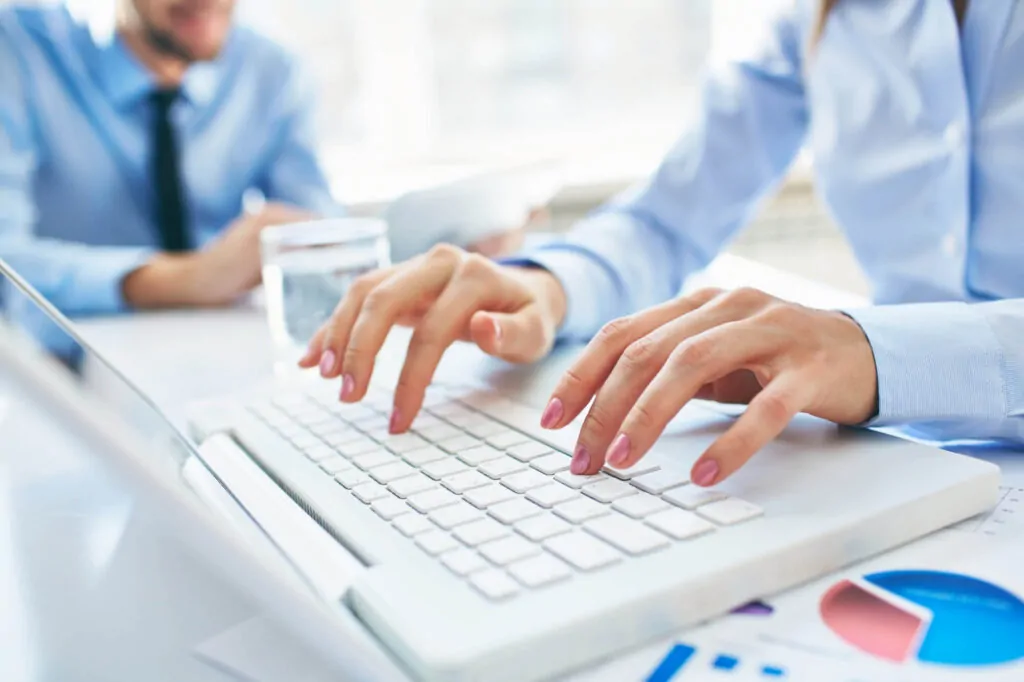 Fingers typing on a keyboard while working on CIS 20 deduction matters in the office.