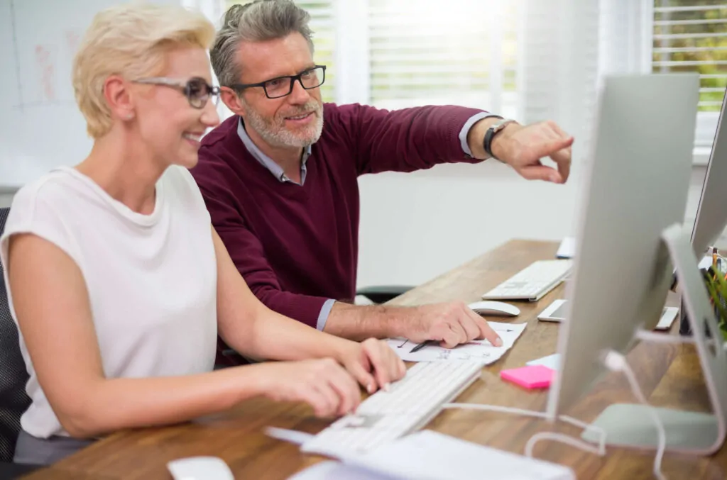 Team of pension scheme specialists discussing retirement fund setup around a desk