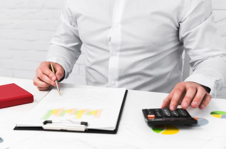 Accountant calculating income tax with documents – Reliable tax return and compliance services by Audit Consulting Group